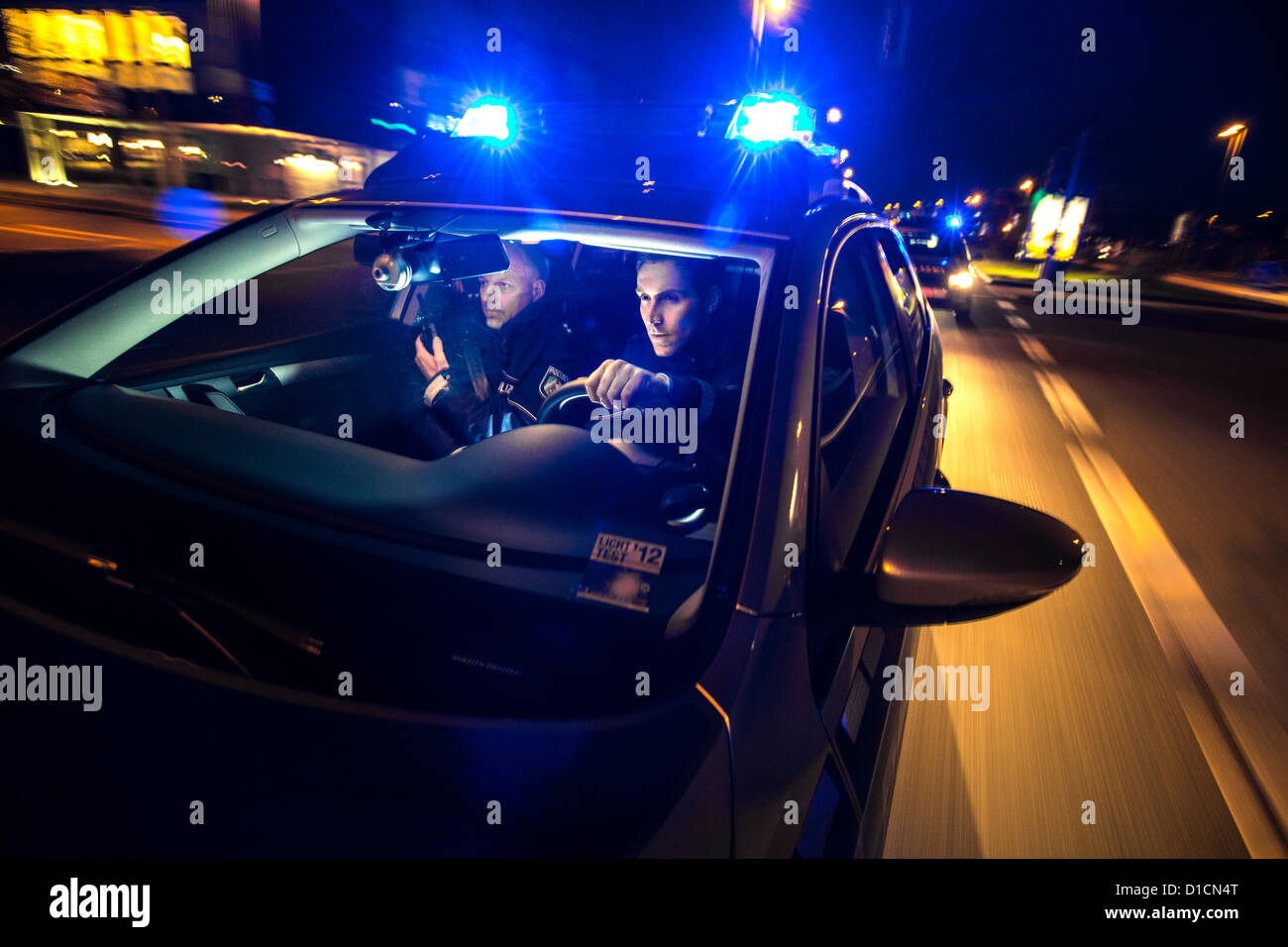 Police patrol car with blue flashing lights, signal horn, driving fast during an emergency mission. Stock Photo