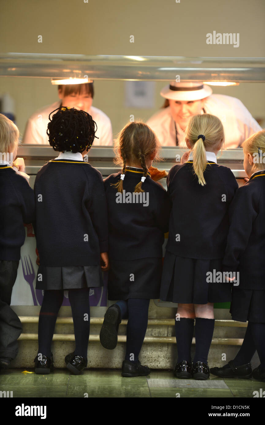 Schoolchildren queuing for toast after morning assembly at Our Lady & St. Werburgh's Catholic Primary School in Newcastle-under- Stock Photo