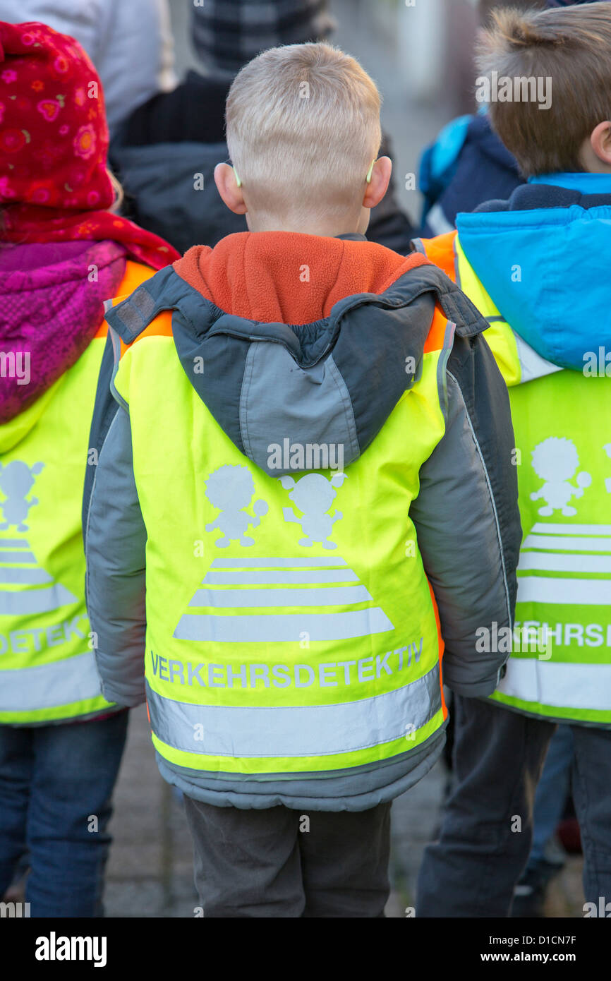 Young school kids, walking to school, with a yellow warn vest, to make them more visible to car drivers. Stock Photo