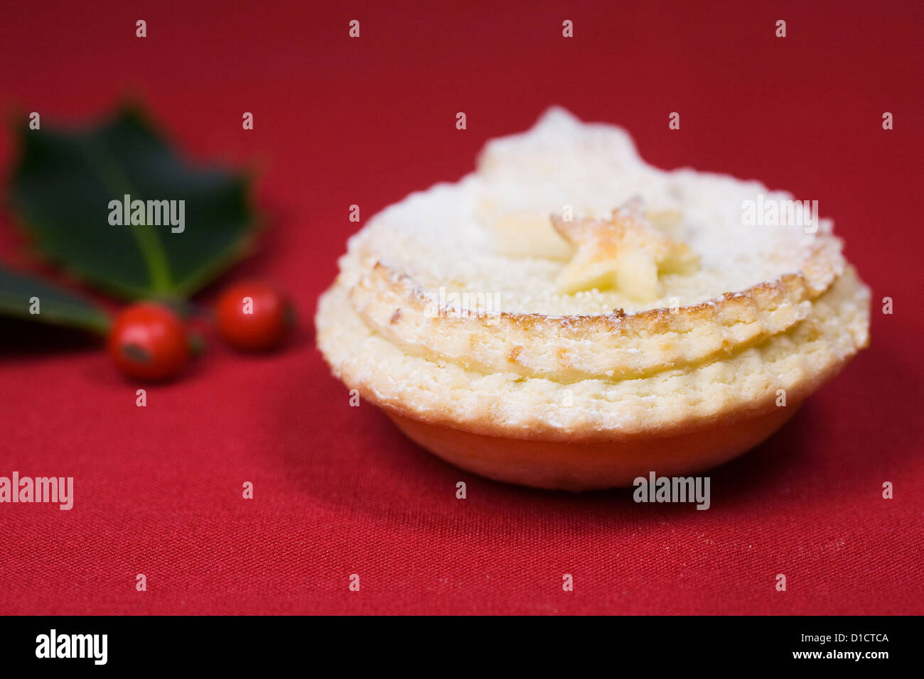 A single mince pie on a red background. Stock Photo