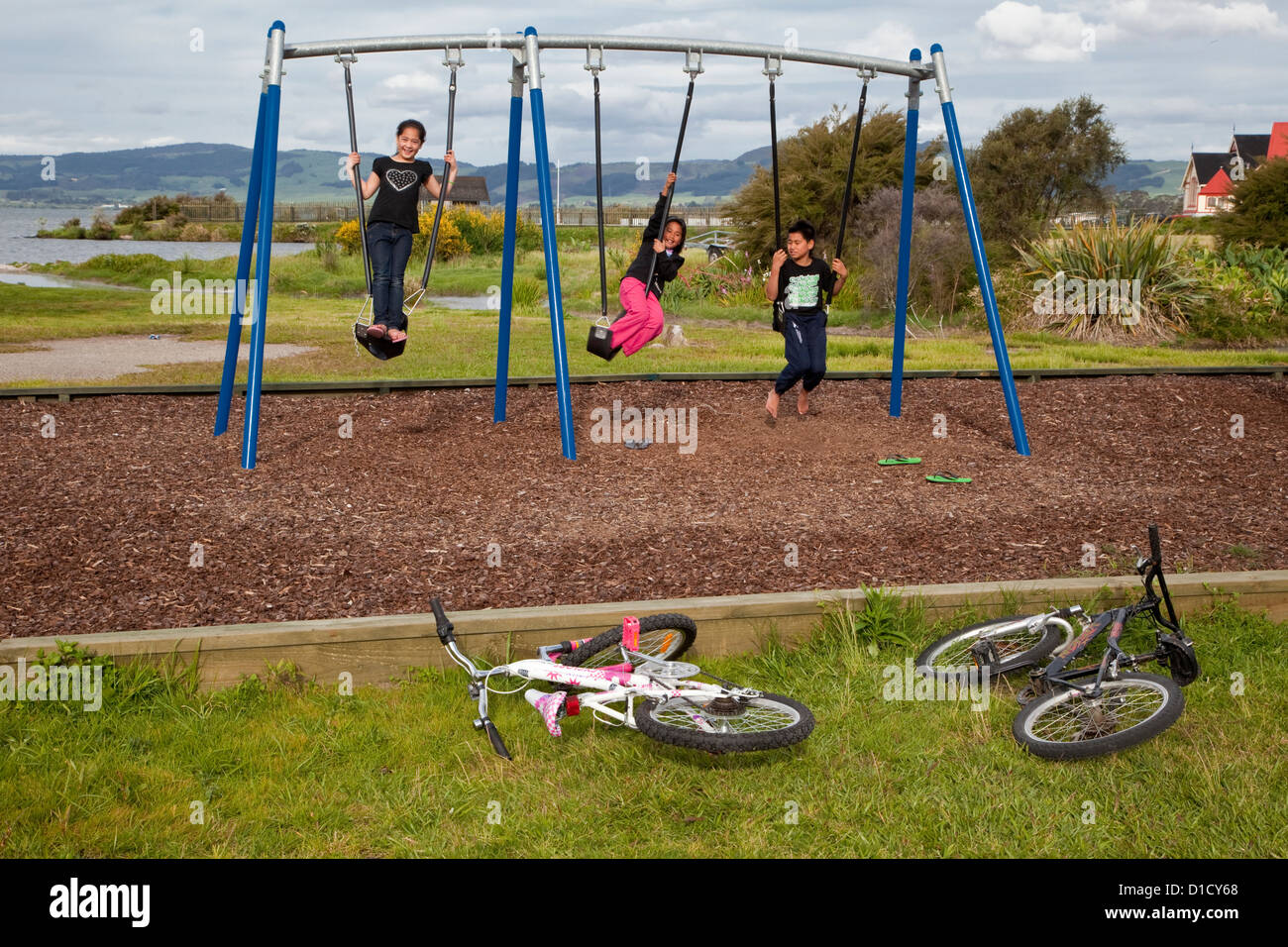 Maori Children Playing on Swings, Ohinemutu Maori Village, Rotorua, north island, New Zealand. Stock Photo