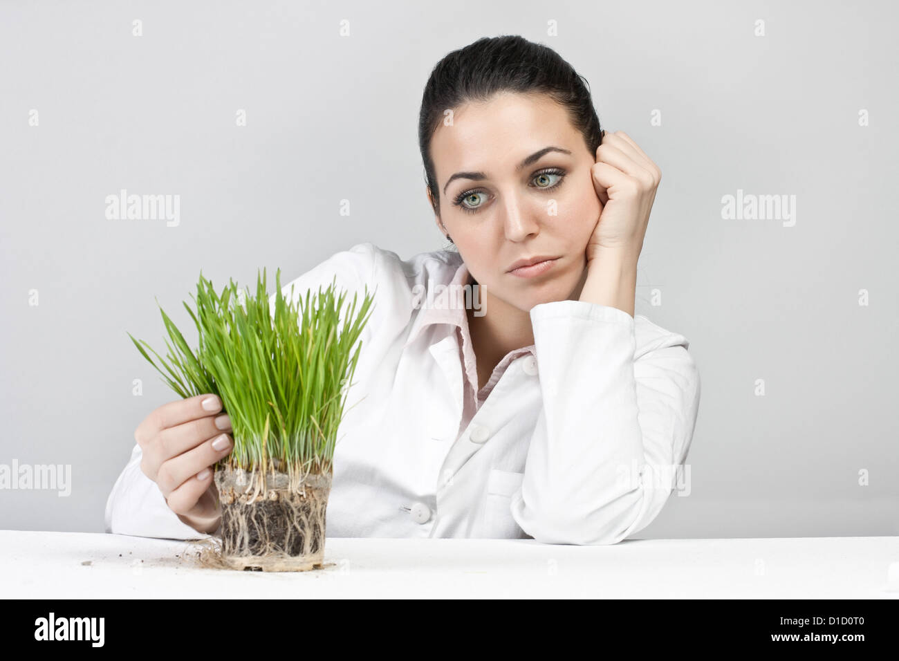 Worried girl watching a plant grow Stock Photo - Alamy