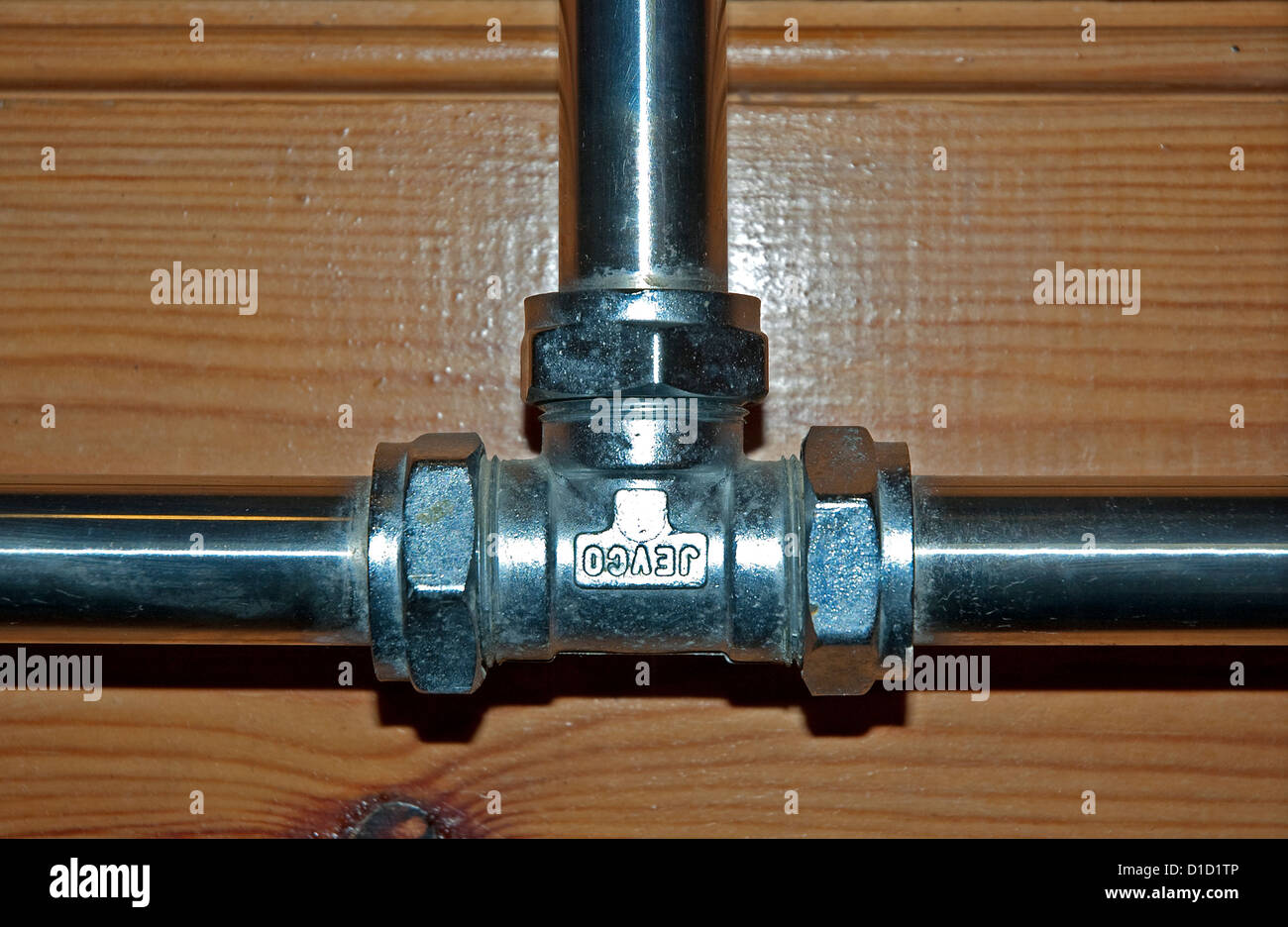 A chrome t-joint carrying the household water supply Stock Photo
