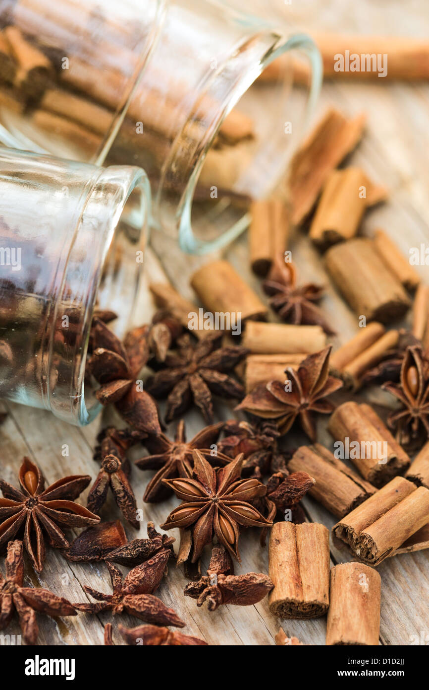 Star anise and cinnamon spilling from glass jars Stock Photo
