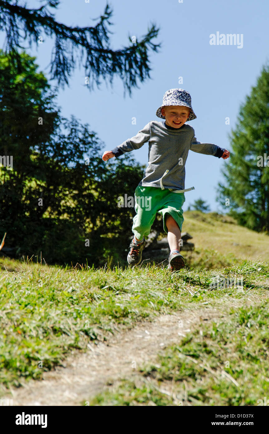 A young boy running along a country track Stock Photo