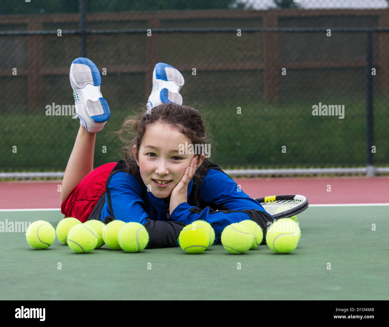 Young girl having fun on outdoor tennis court Stock Photo