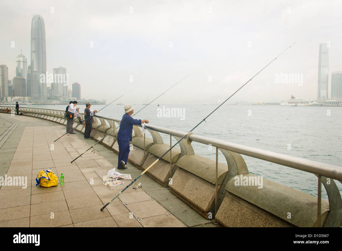 People are fishing at the Wan Chai or Wanchai Waterfront Promenade of Hong Kong, China. Stock Photo