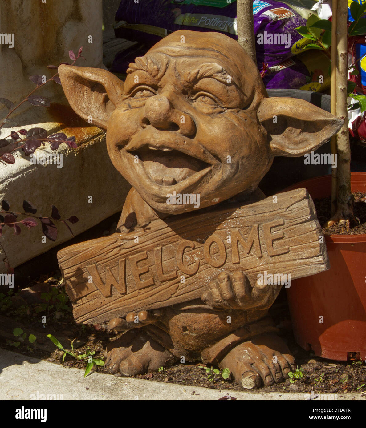 Wooden welcome sign held by smiling elf with large ears Stock Photo