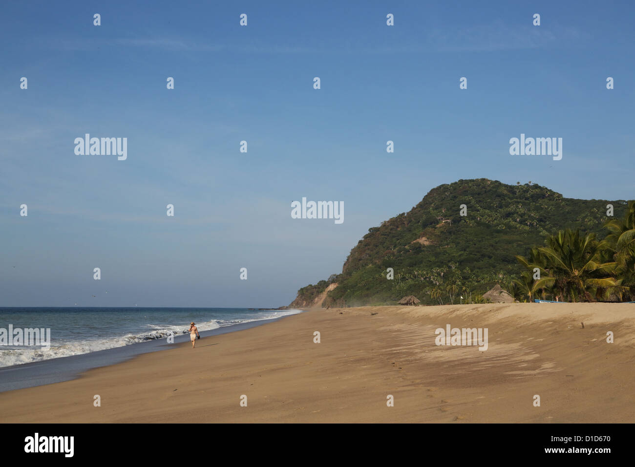 A man walking on the beach at San Pancho, Nayarit, Mexico. Stock Photo