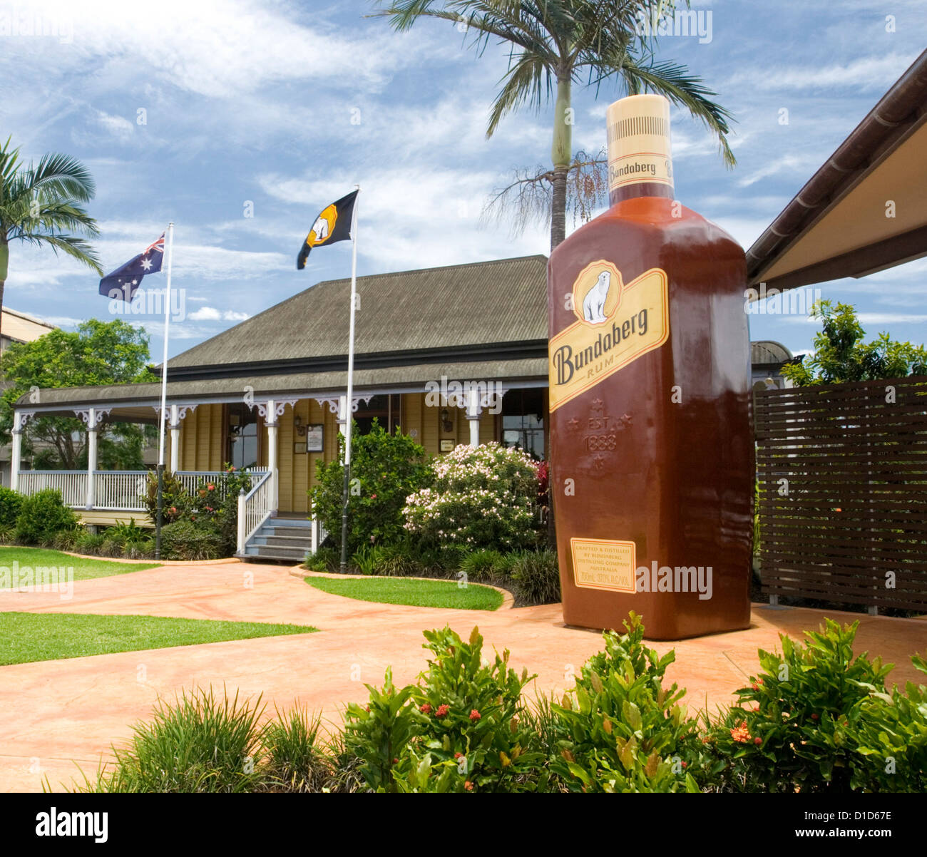 Entrance to Bundaberg rum distillery / bond store tourist attraction with old cottage and gigantic bottle of rum Stock Photo