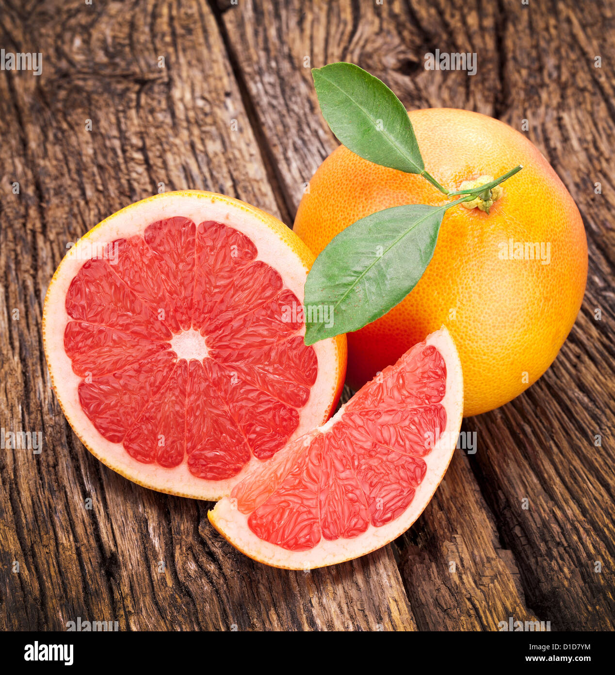 Grapefruit with slices on a wooden table. Stock Photo