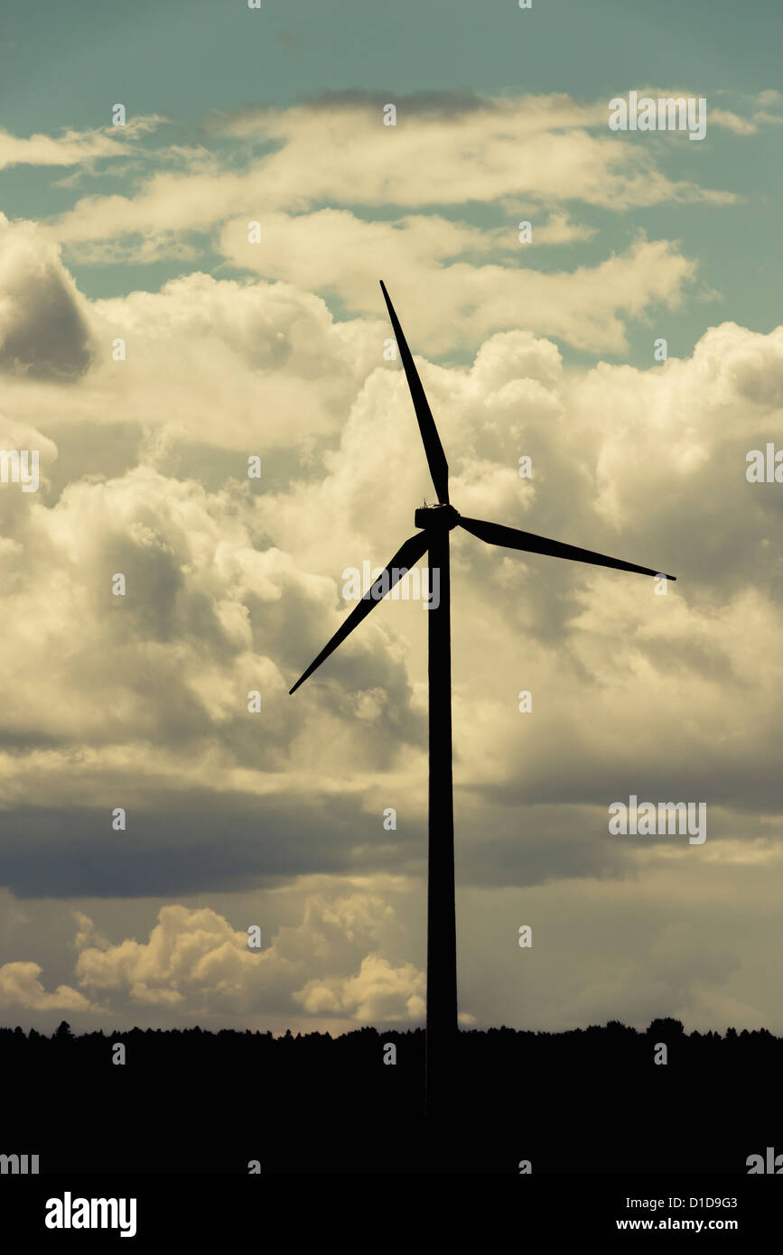 Silhouette of modern windmill generating electricity with dramatic sky Stock Photo