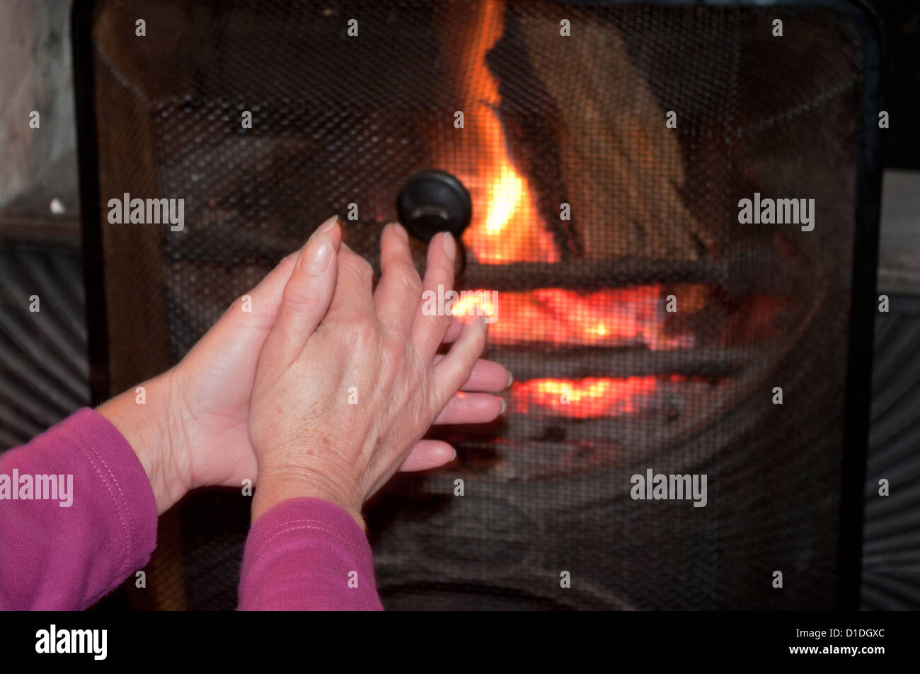 Rubbing Hands Together In Front Of An Open Fire Stock Photo