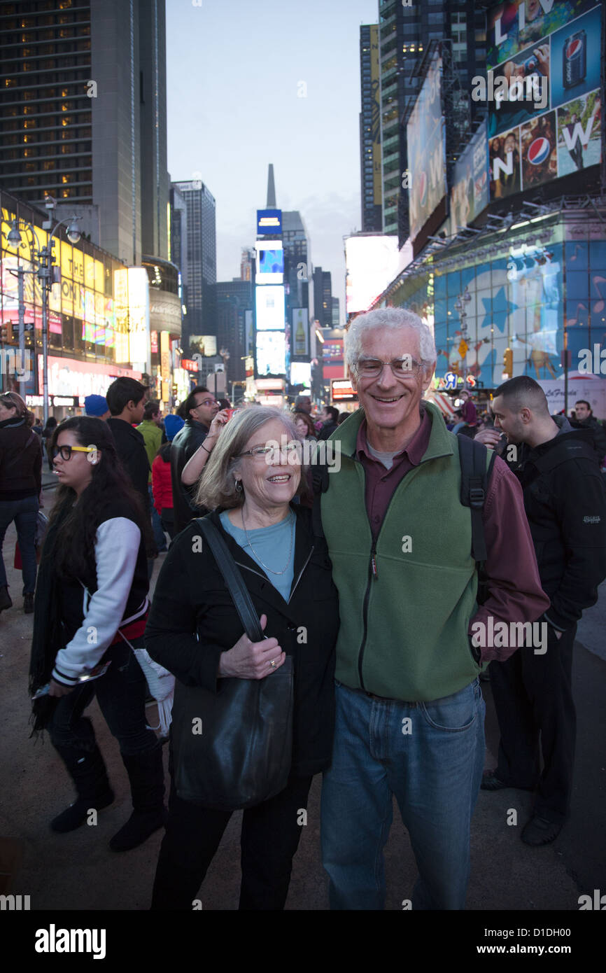 Healthy looking couple of 70 year olds make a photo memory in Times Square, NYC. Stock Photo