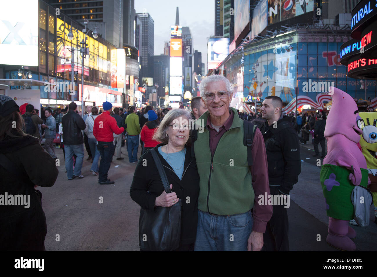 Healthy looking couple of 70 year olds make a photo memory in Times Square, NYC. Stock Photo