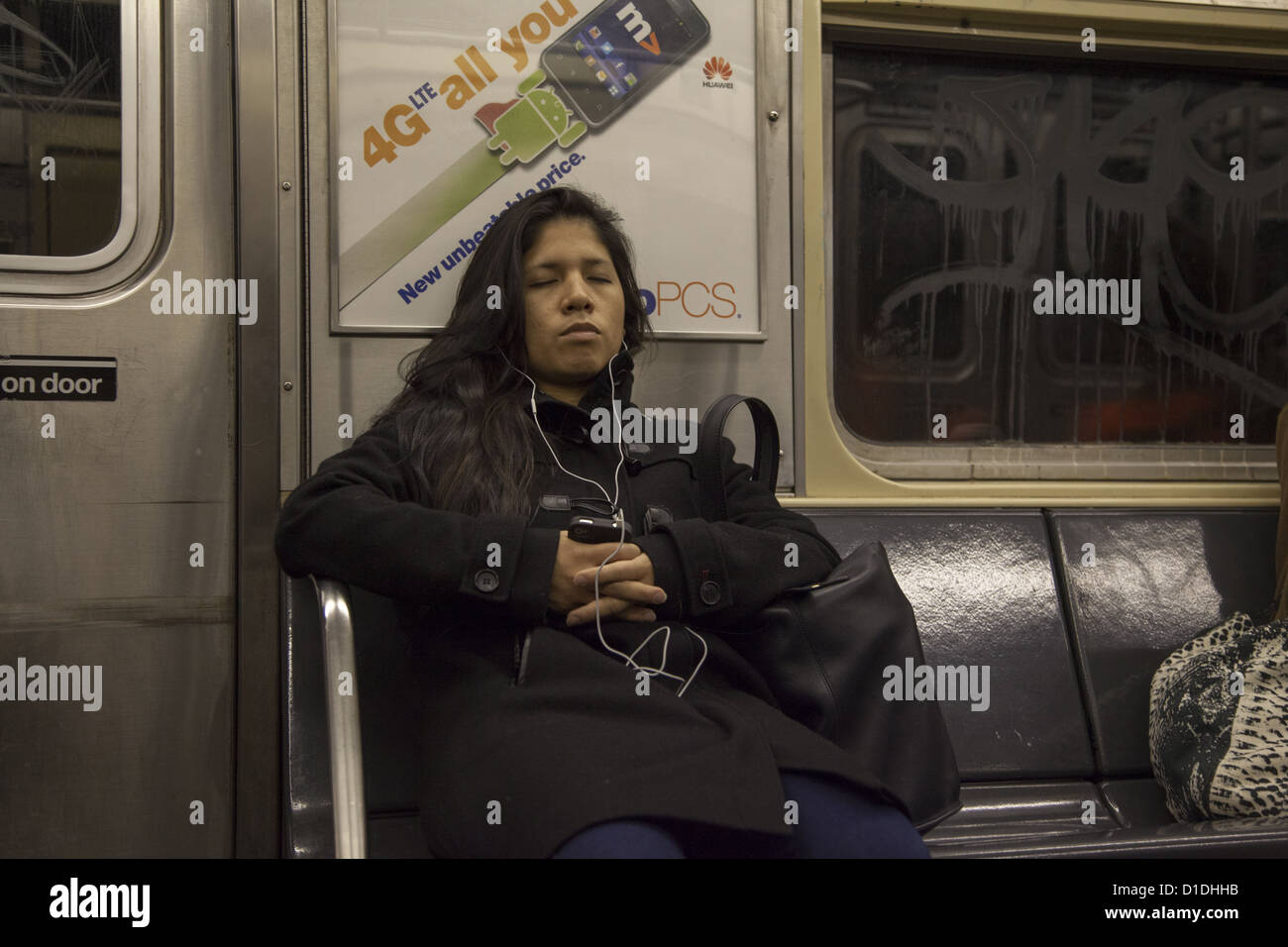 Women listens to music while riding the NYC subway in Manhattan Stock Photo Alamy