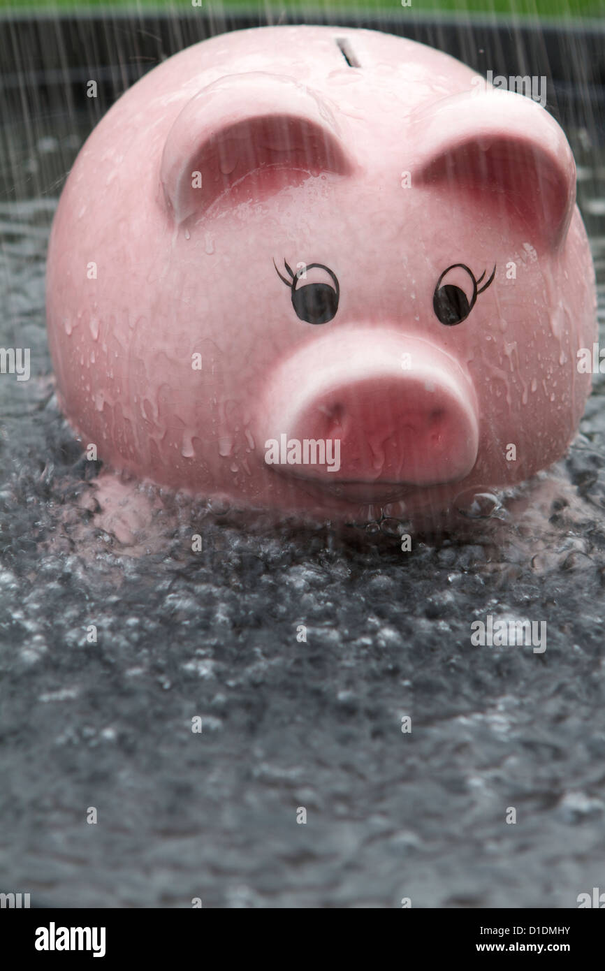 Pink Piggy bank getting wet in the rain Stock Photo