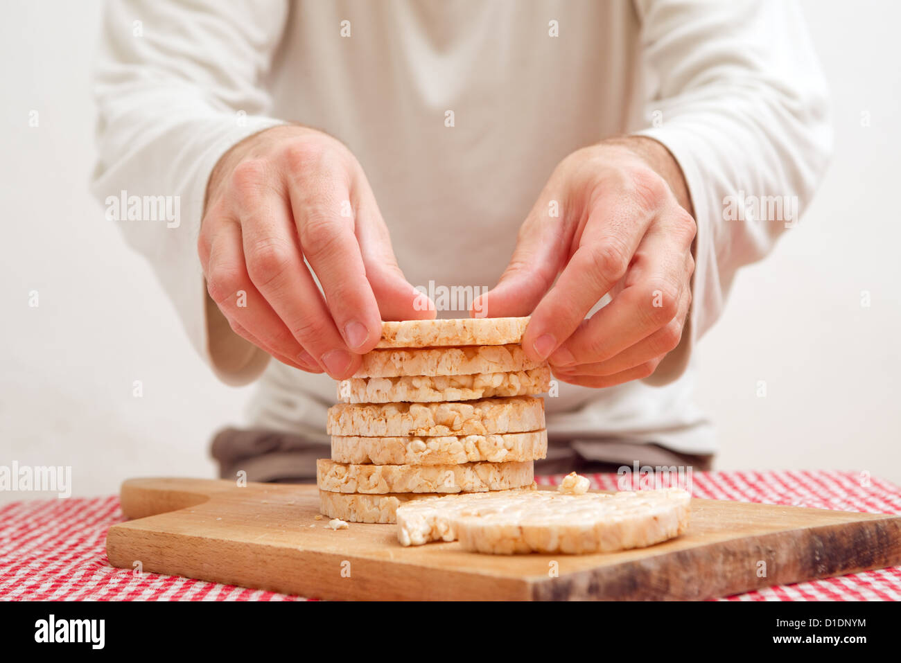 Man holding tasty rice cake on a kitchen table Stock Photo