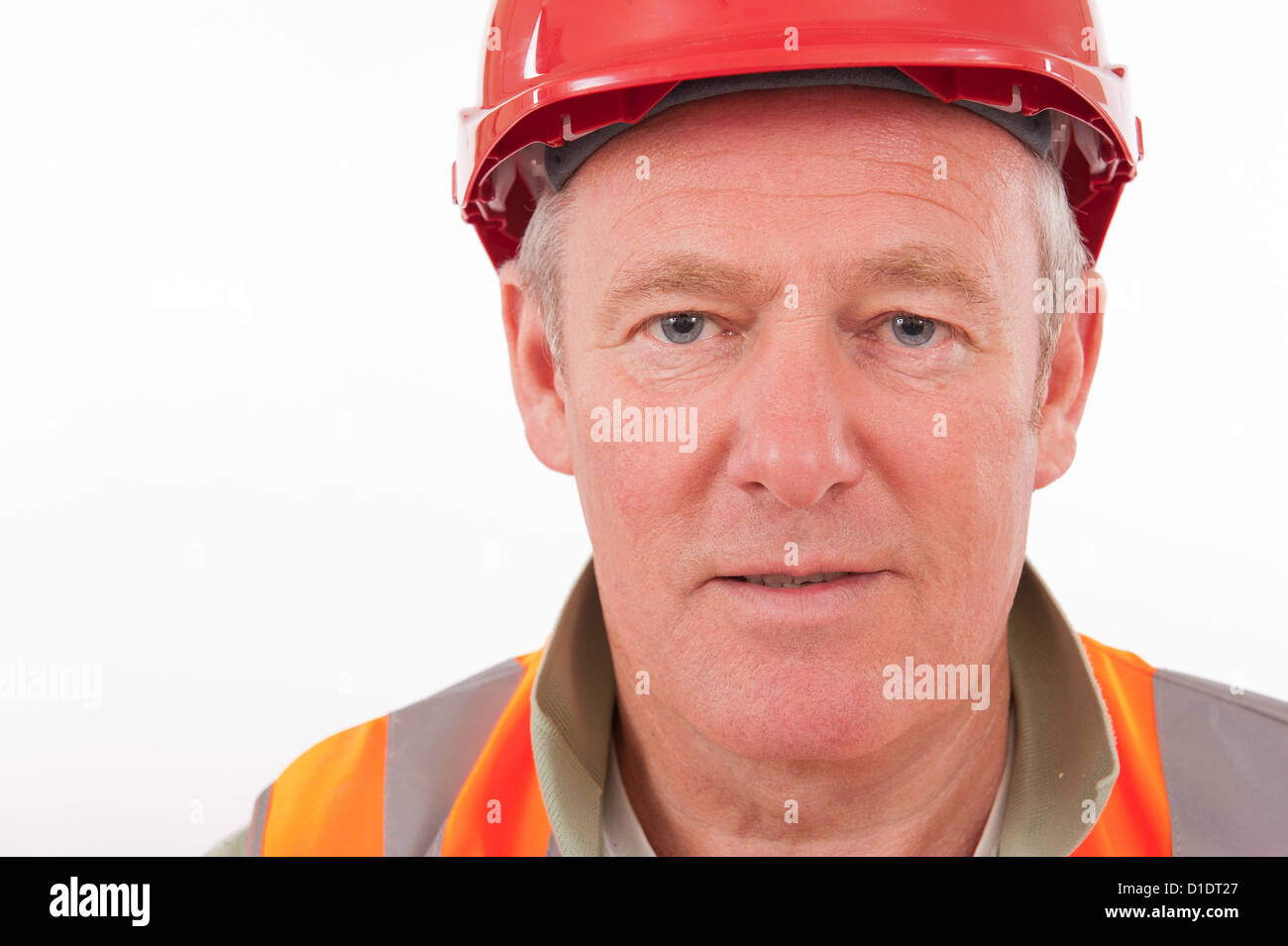 Close up portrait of a construction worker wearing a red hard hat and bright hi-viz jacket. Stock Photo