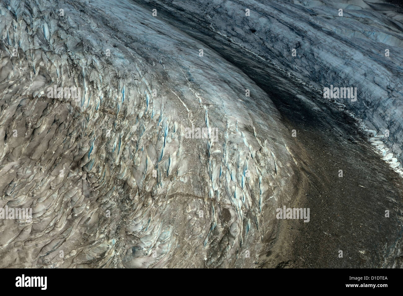 A landscape image of the sweeping south west arm of the Salmon Glacier showing moraine gravel and cracks in the surface of the g Stock Photo