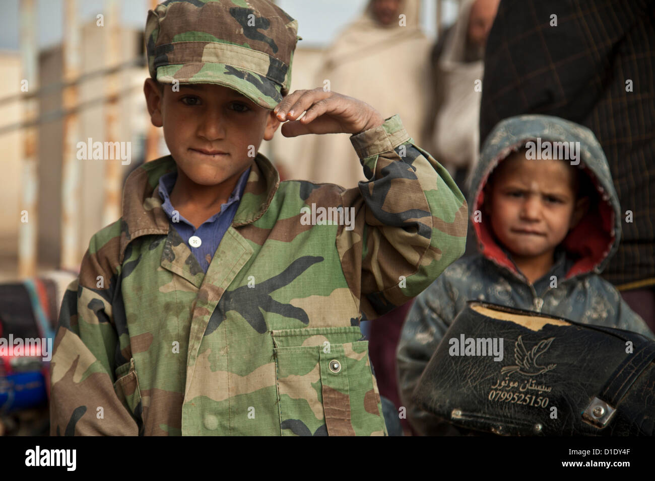 A Afghan boy salutes US Special Forces during a patrol December 16, 2012 in Farah province, Afghanistan. Stock Photo