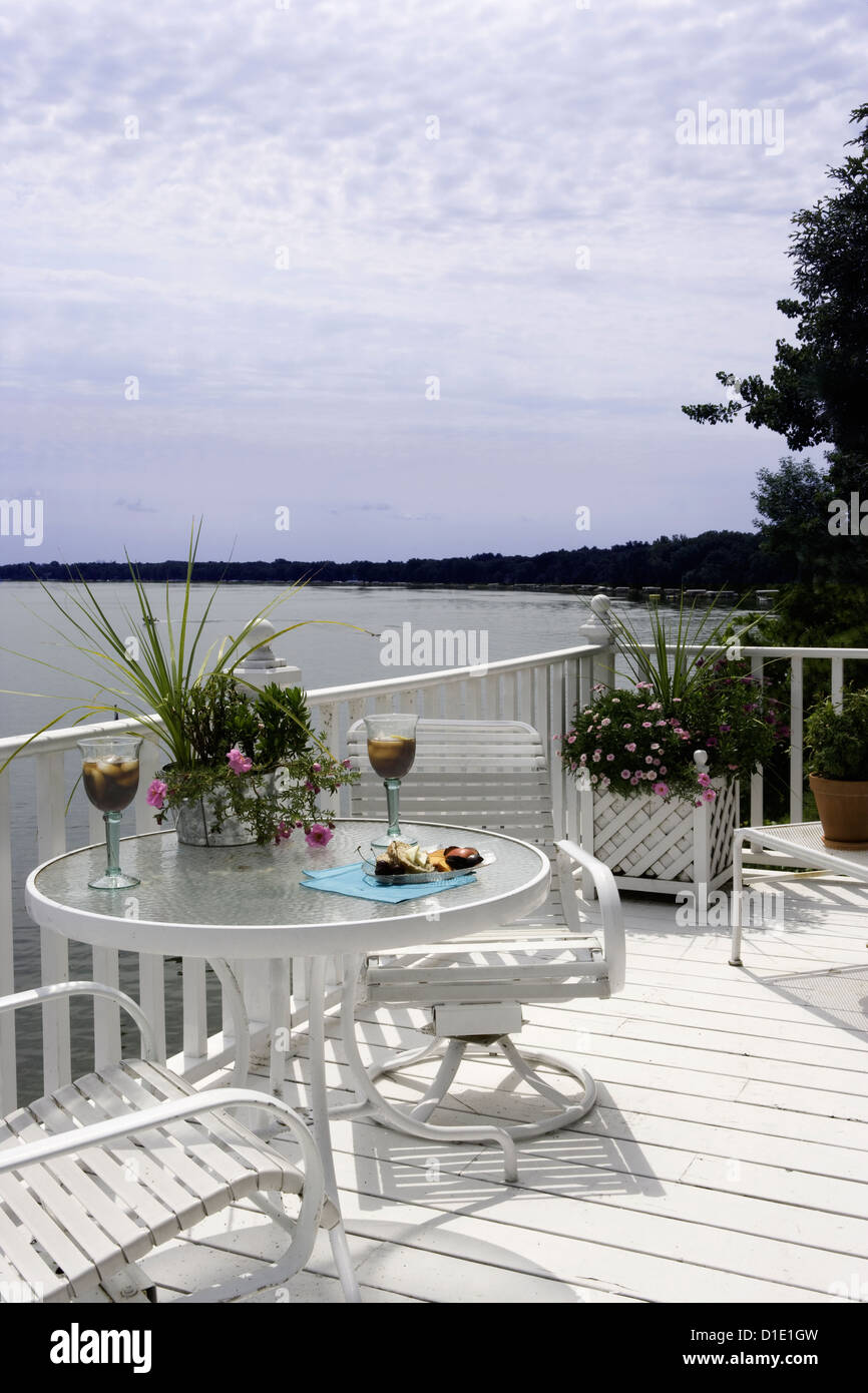 DECKS; upper third story deck overlooking lake all white small table with chairs potted flowers