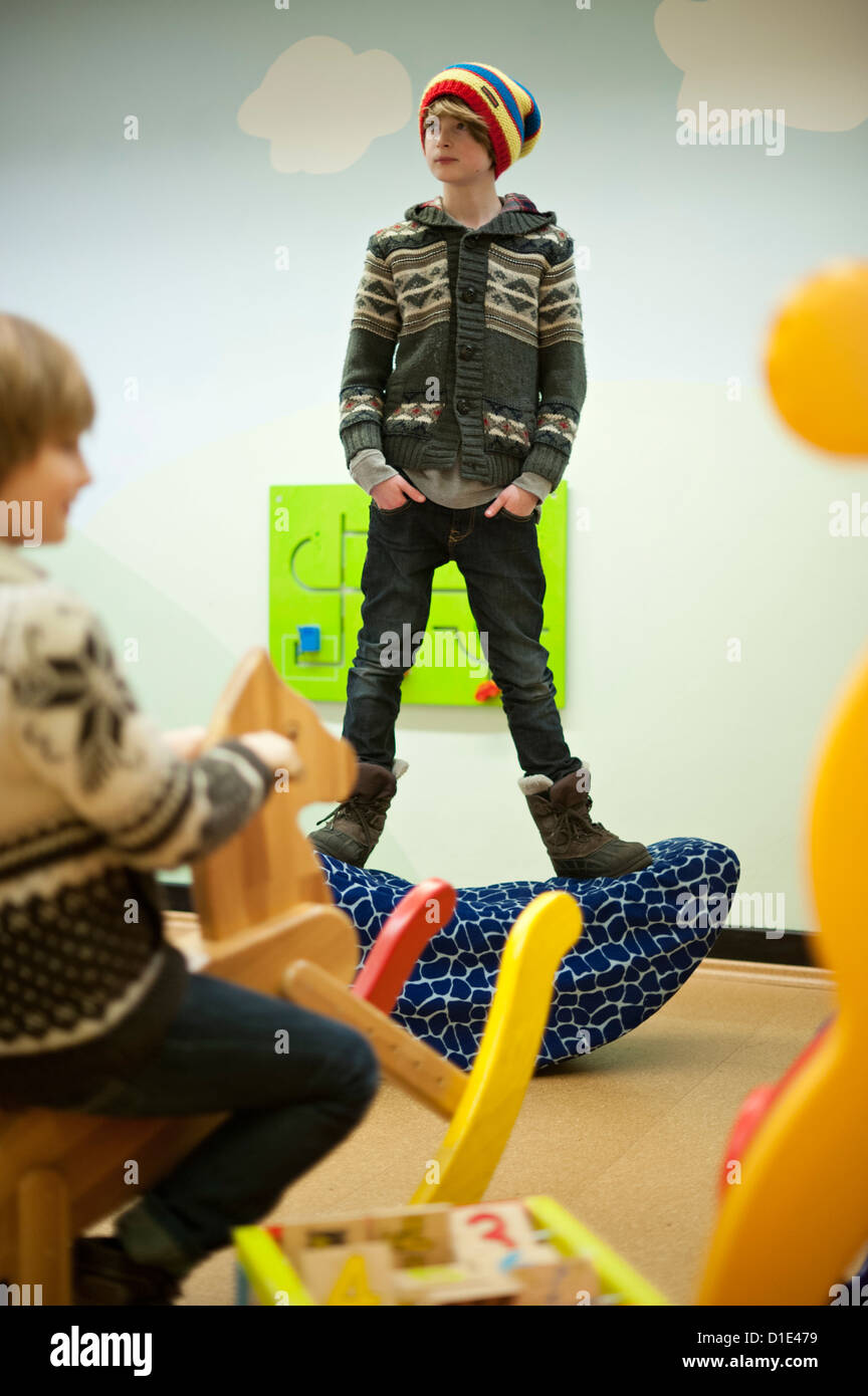 Oaskar (R) and his brother play in the waiting room of the Centre for Auditory Medical Conditions of the Medical University Hanover (MHH) in Hanover, Germany, 03 December 2012. Oscar received an inner ear implants (Cochlea implants) which convert sound waves inro electrical impiulses and allow children bron deaf to hear. Photo: Emily Wabitsch Stock Photo