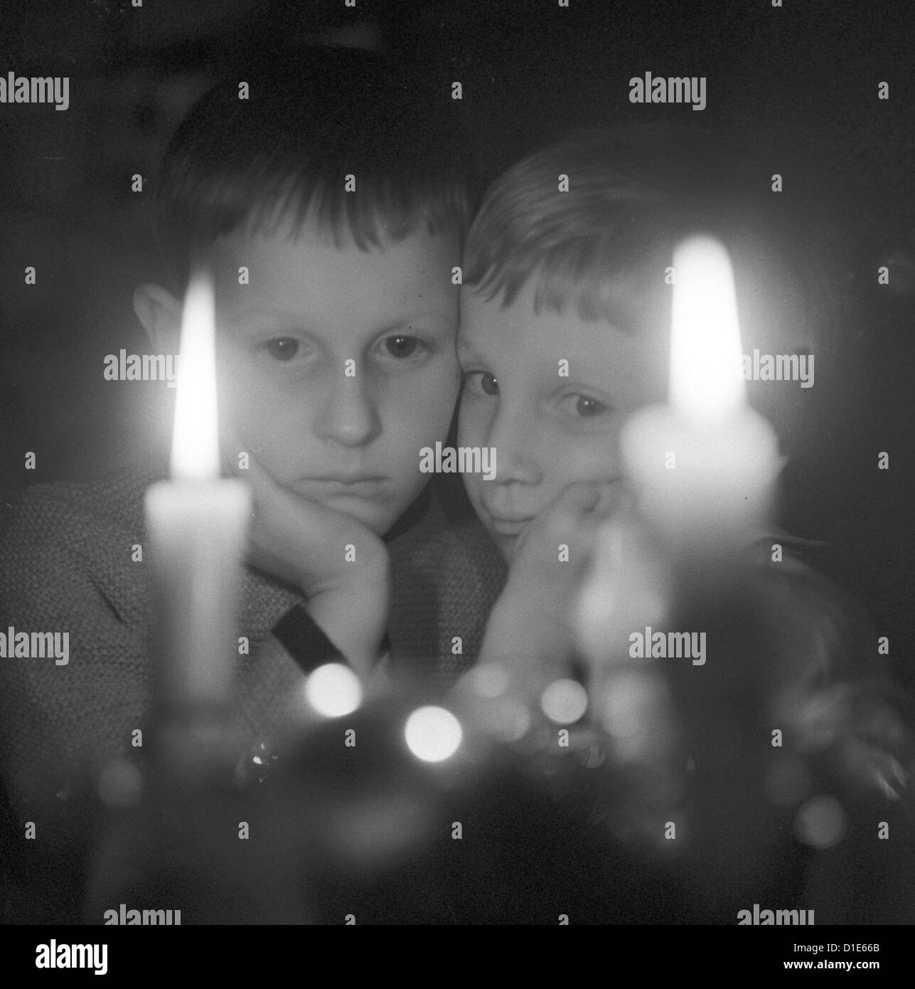 Advent Two children look at two burning candles. Undated photo from