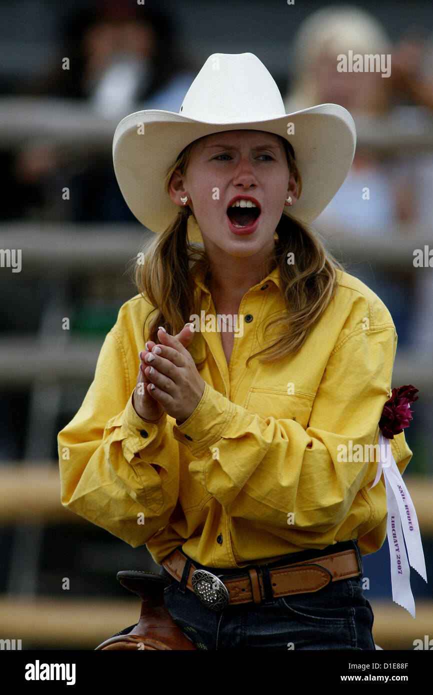 cowgirl riding in a yellow shirt with hat Stock Photo