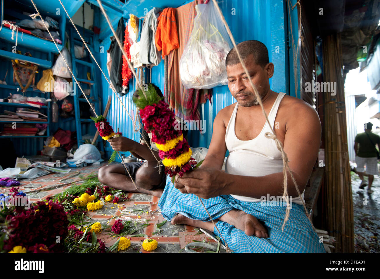 Mala makers (garland makers) at work in Kolkata's morning flower market, Howrah, Kolkata, West Bengal, India, Asia Stock Photo