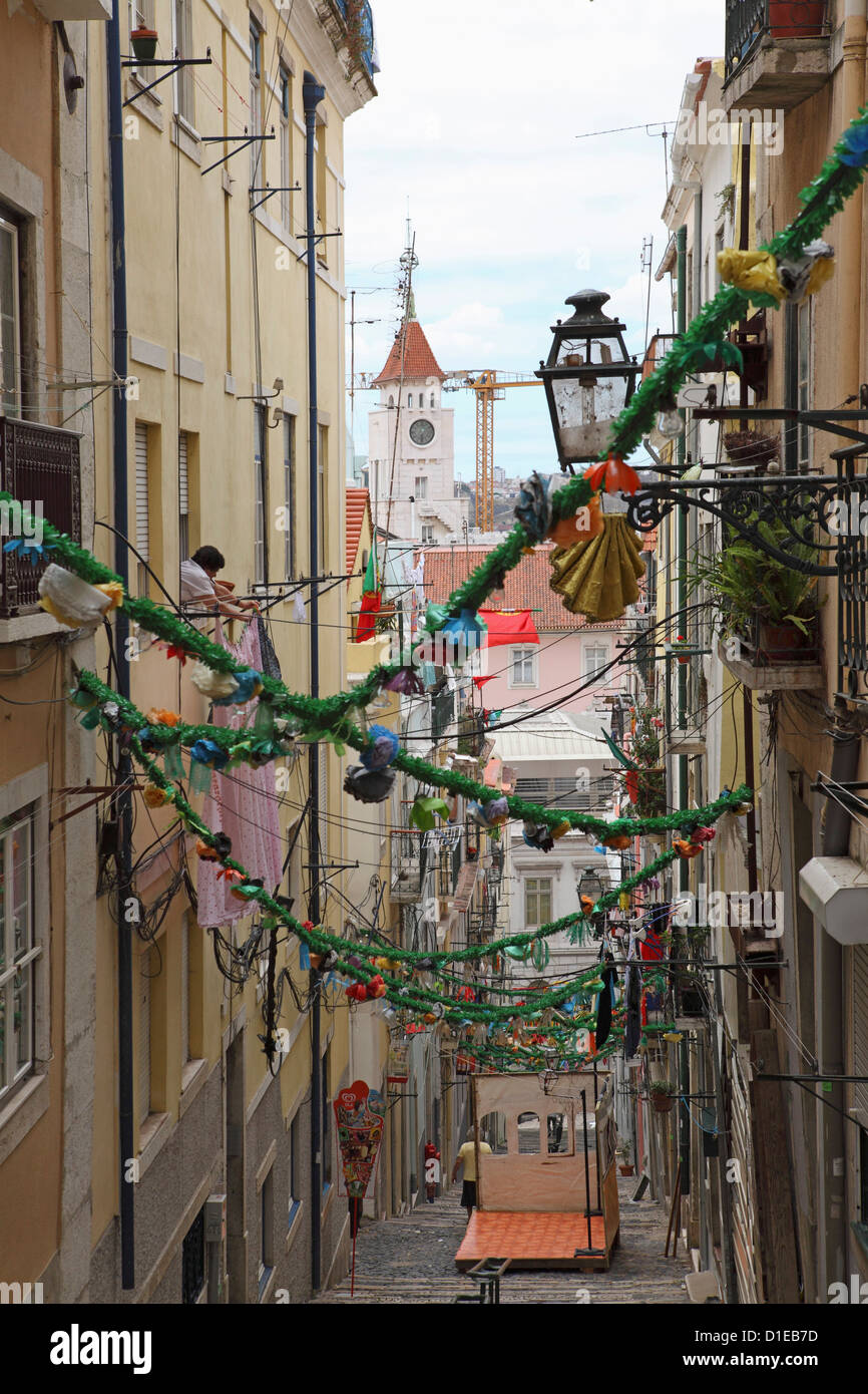 An alley is decorated with tinsel and colour for the annual Festival of St. Anthony in the Bica district of Lisbon, Portugal Stock Photo