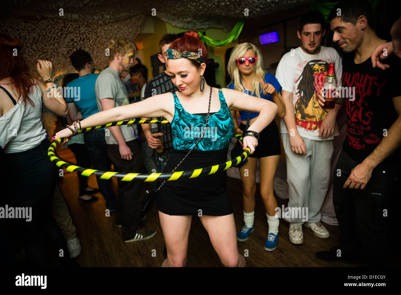 A girl dancing with a hula hoop - Aberystwyth university student partying at a dance night in the Students Union, Wales UK Stock Photo