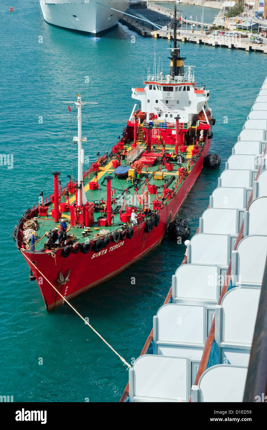 Refuelling tanker comes alongside a newlyarrived cruise ship in Grand