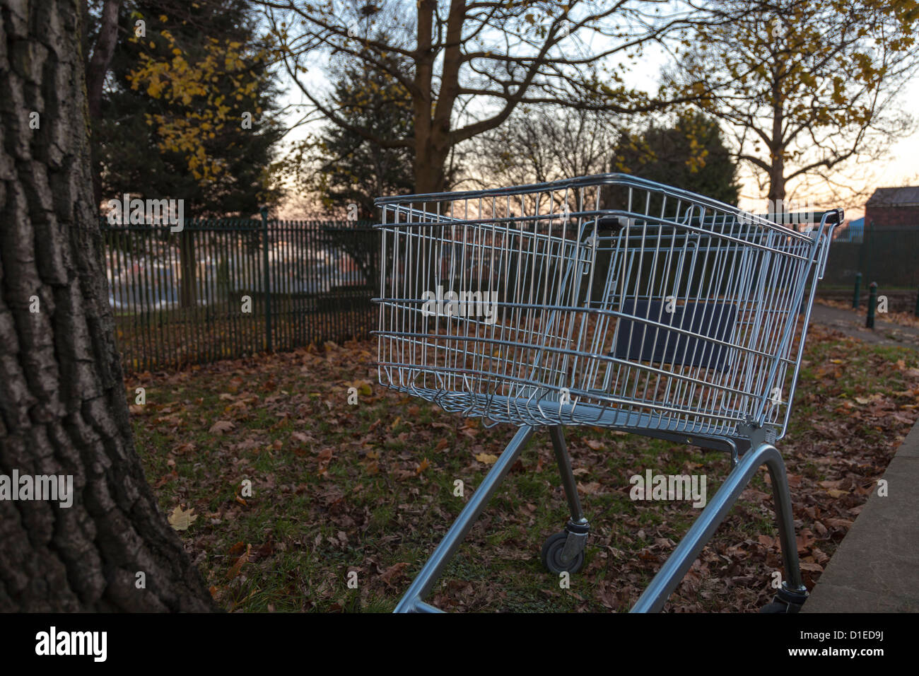 Shopping trolley dumped outside suburban park. Stock Photo