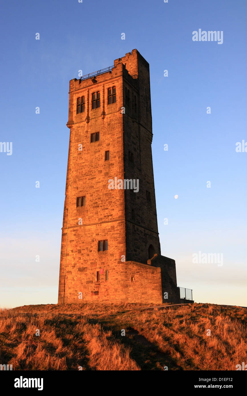 The moon rises behind Victoria Tower on Castle Hill, the well known landmark in Almondbury, Huddersfield, West Yorkshire Stock Photo