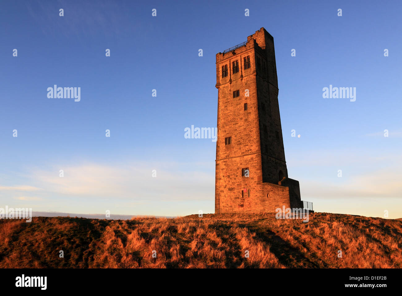 The moon rises behind Victoria Tower on Castle Hill, the well known landmark in Almondbury, Huddersfield, West Yorkshire Stock Photo