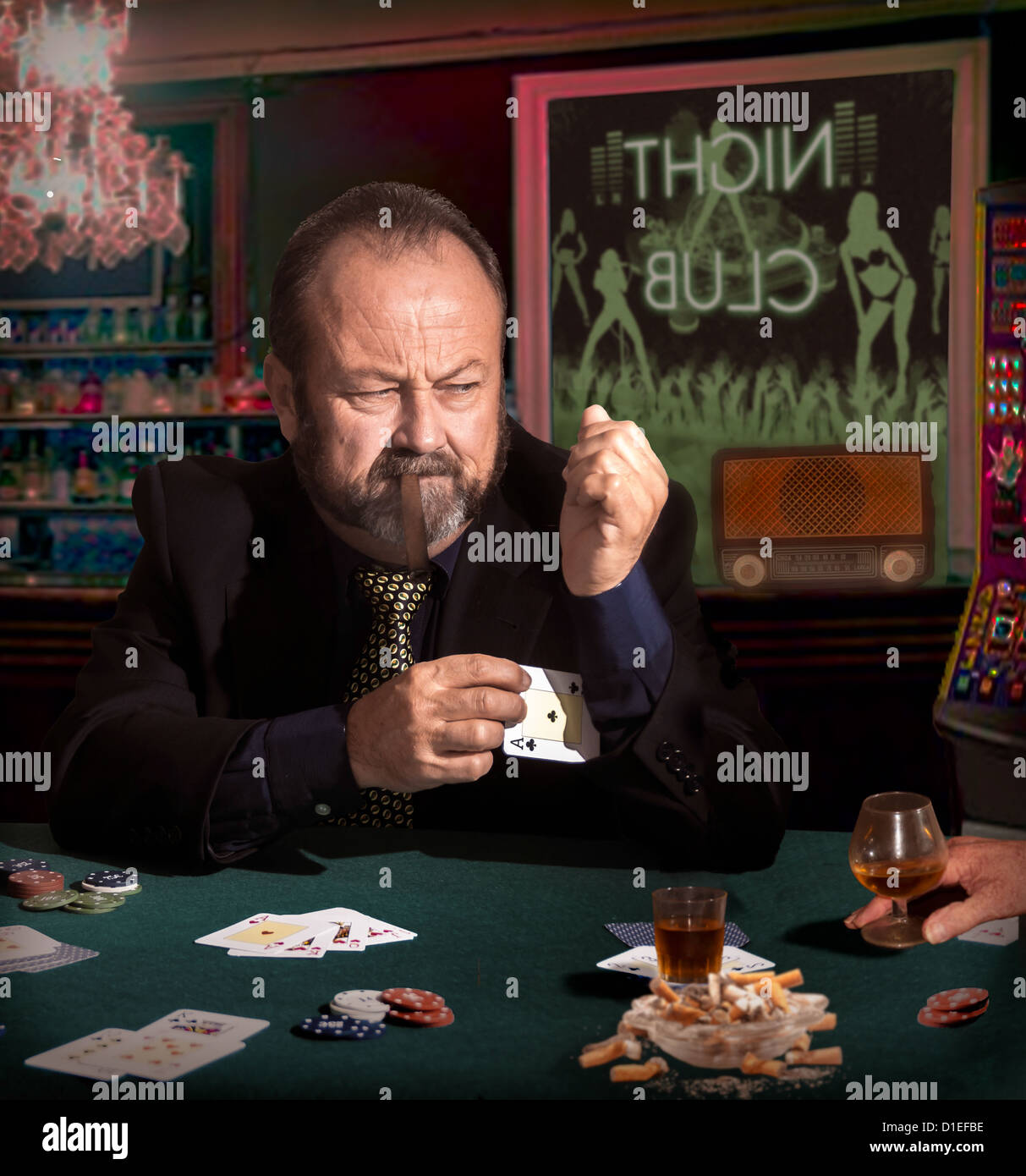 Man cheating at a game of poker. He puts an ace up his sleeve Stock Photo