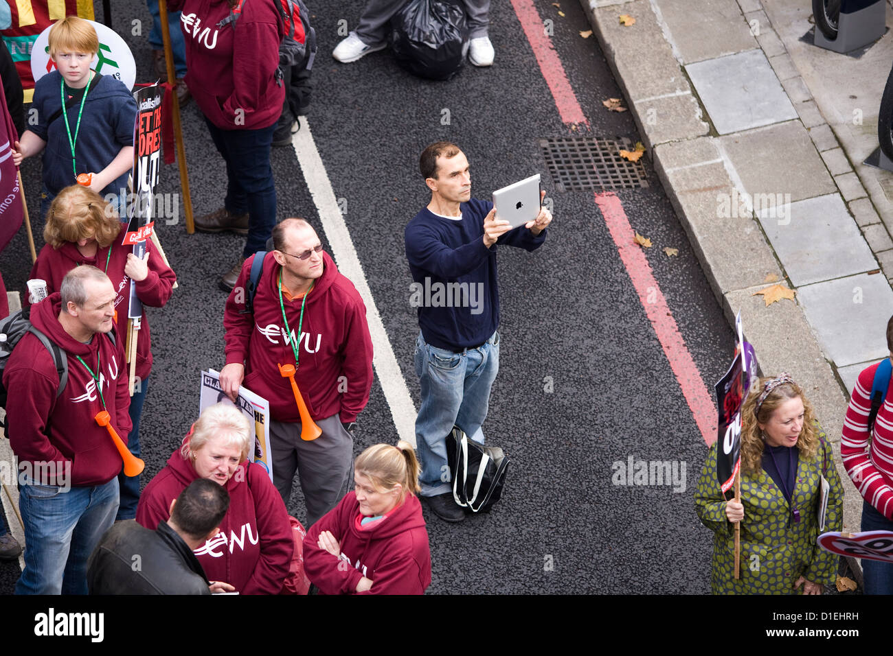 Marcher / protestor / photographer taking a photo / photograph / snap with an iPad / i Pad during a union march in London, UK. Stock Photo