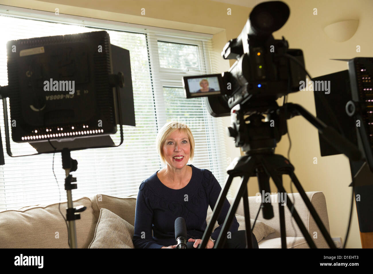 A female presenter in front of a camera for video film production Stock Photo