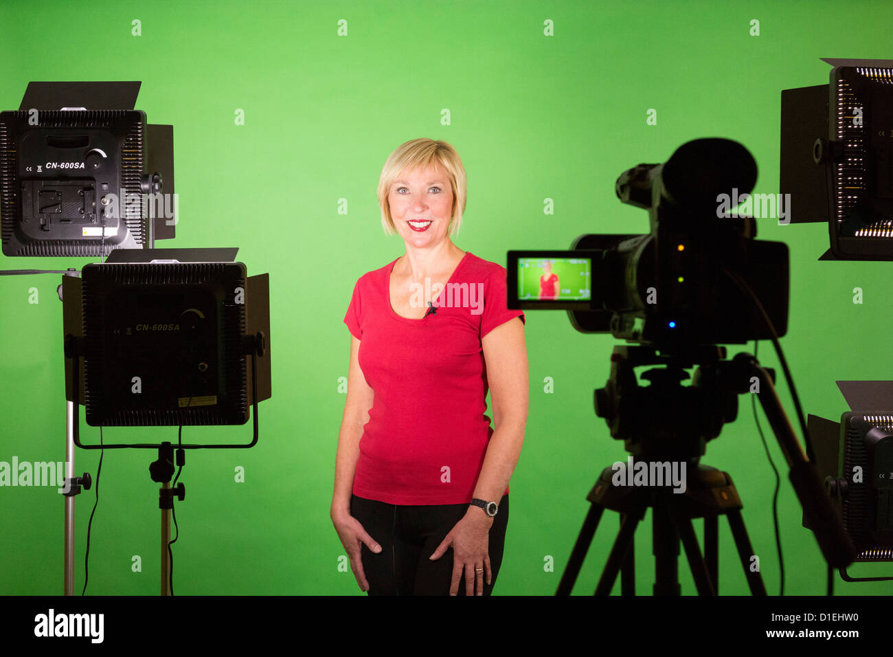 A female presenter in front of a camera for video film production Stock Photo