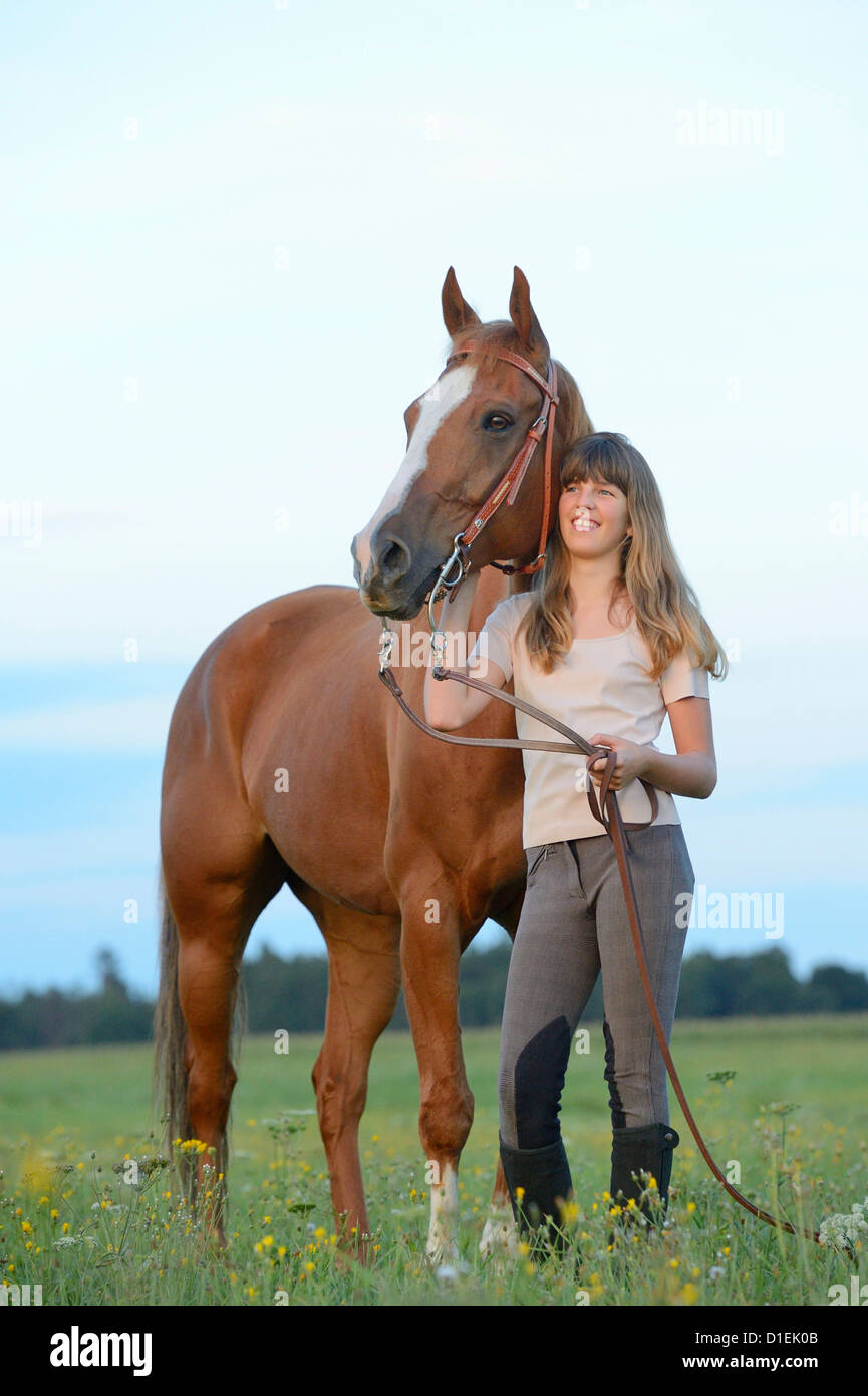 Smiling teenage girl with horse on meadow Stock Photo - Alamy