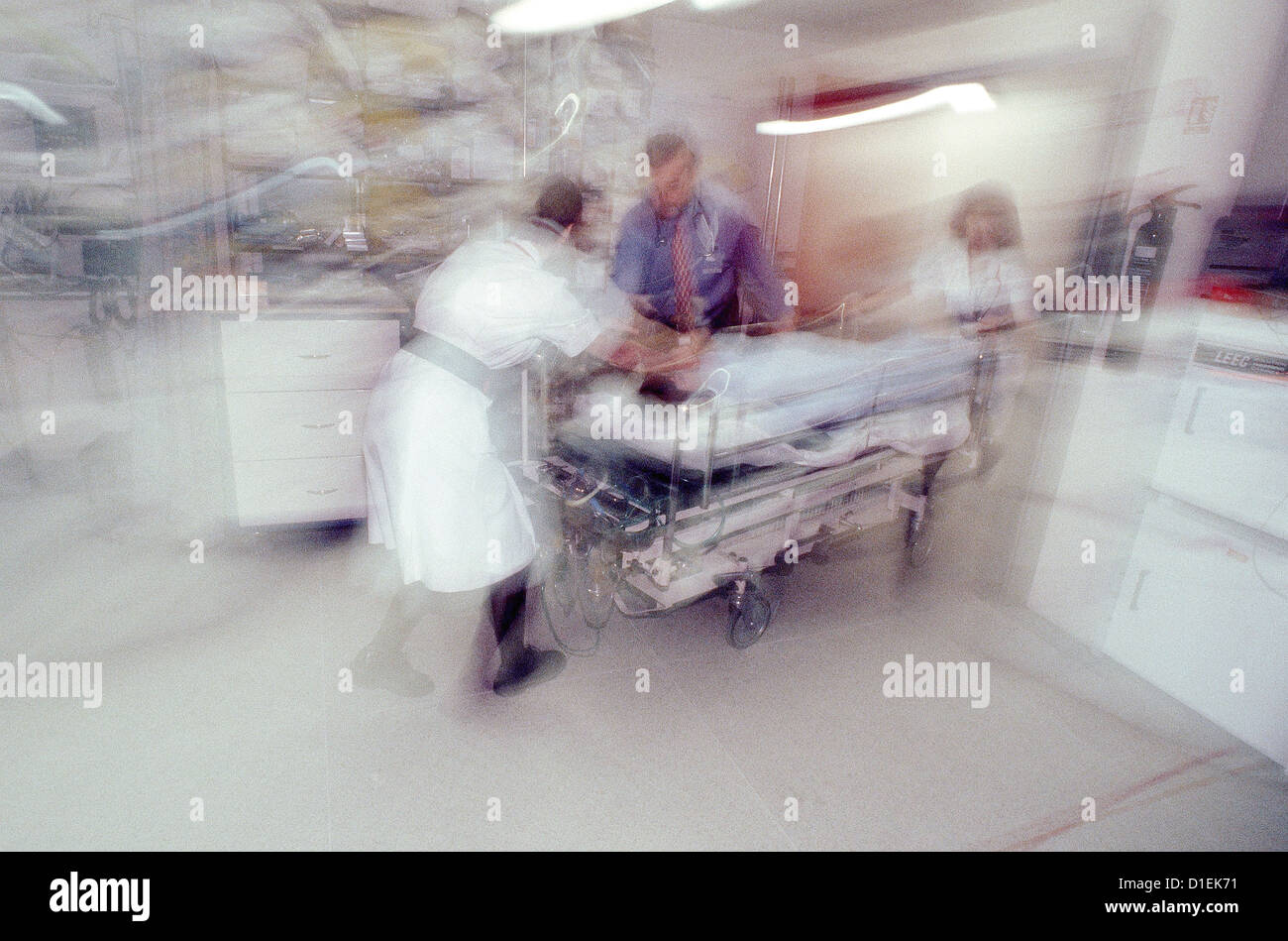 Doctors and nurses rush a patient on a trolley into the crash room of an accident and emergency department. Stock Photo