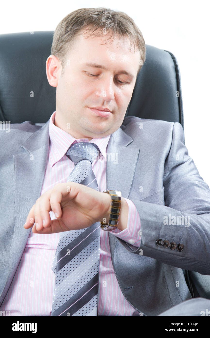 Close up portrait of a handsome young business man in a stylish suit look on watch on his hand  isolated on white.More of this Stock Photo