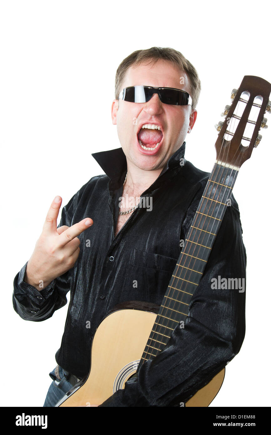rock musician, man in glasses with guitar screams and shows a sign of victory with his fingers on a white background. Stock Photo