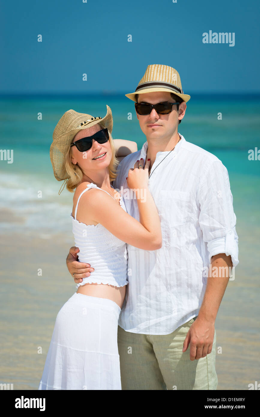 Embracing Young Couple In Sunglasses And White Dress On A