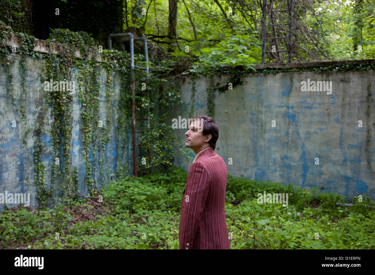 Man in Overgrown Abandoned Place Stock Photo
