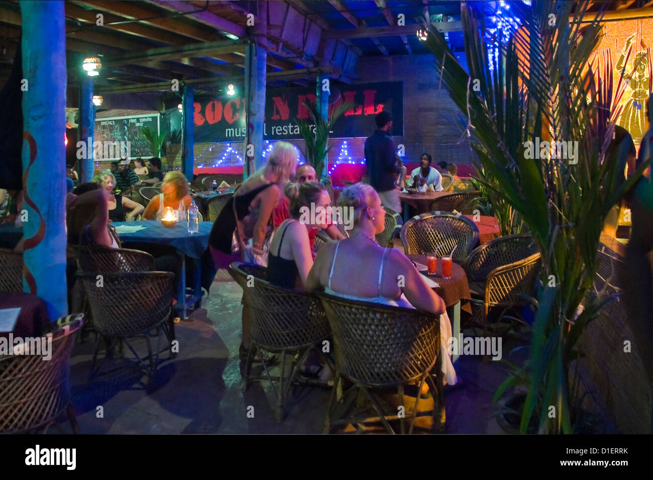 Horizontal nightime view of people enjoying themselves at a night club and bar in Varkala, Kerala. Stock Photo