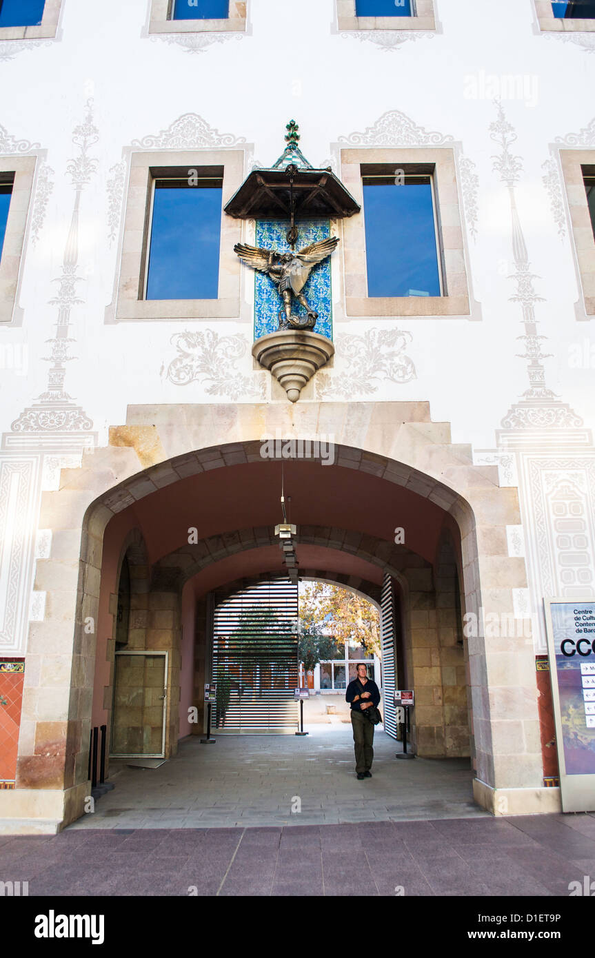 Man passing though courtyard entry arch into the CCCB contemporary art museum in Barcelona, Spain with St. Geoge & the Dragon sc Stock Photo