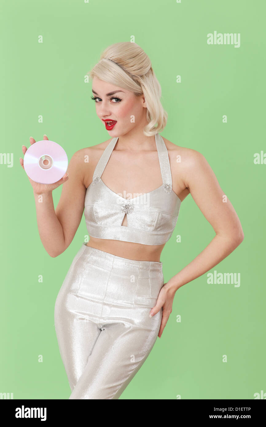 Woman in silver outfit holding  a CD Stock Photo