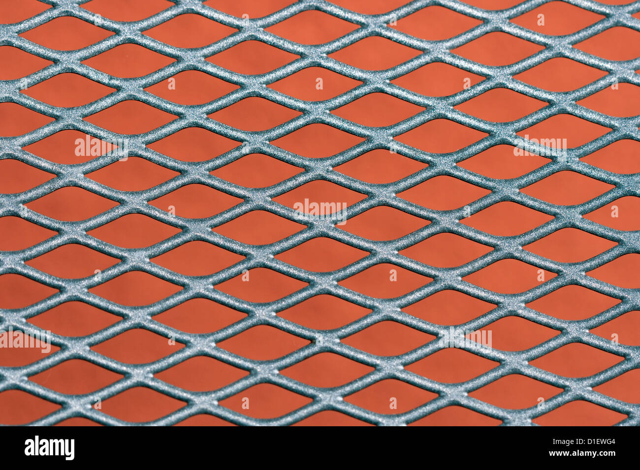 Abstract metal grating against red wall background Stock Photo